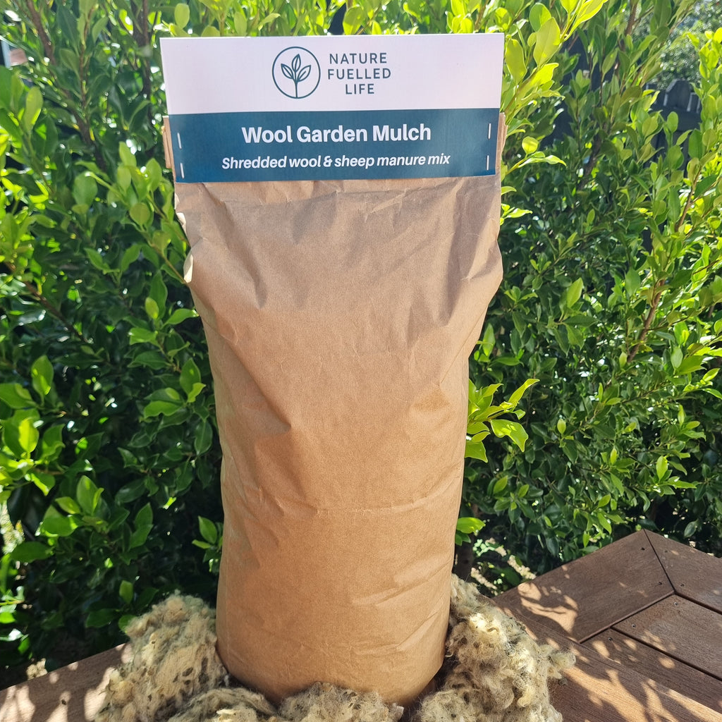 Wool garden mulch with a visible brand label against a green leafy background