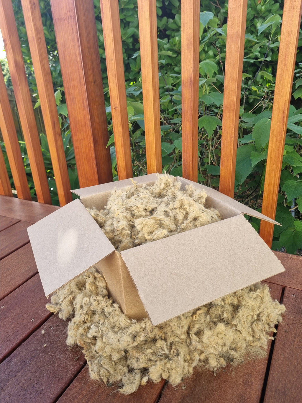 Natural wool garden mulch made from New Zealand wool and sheep manure, eco-friendly moisture-retaining mulch for gardens and flower beds.